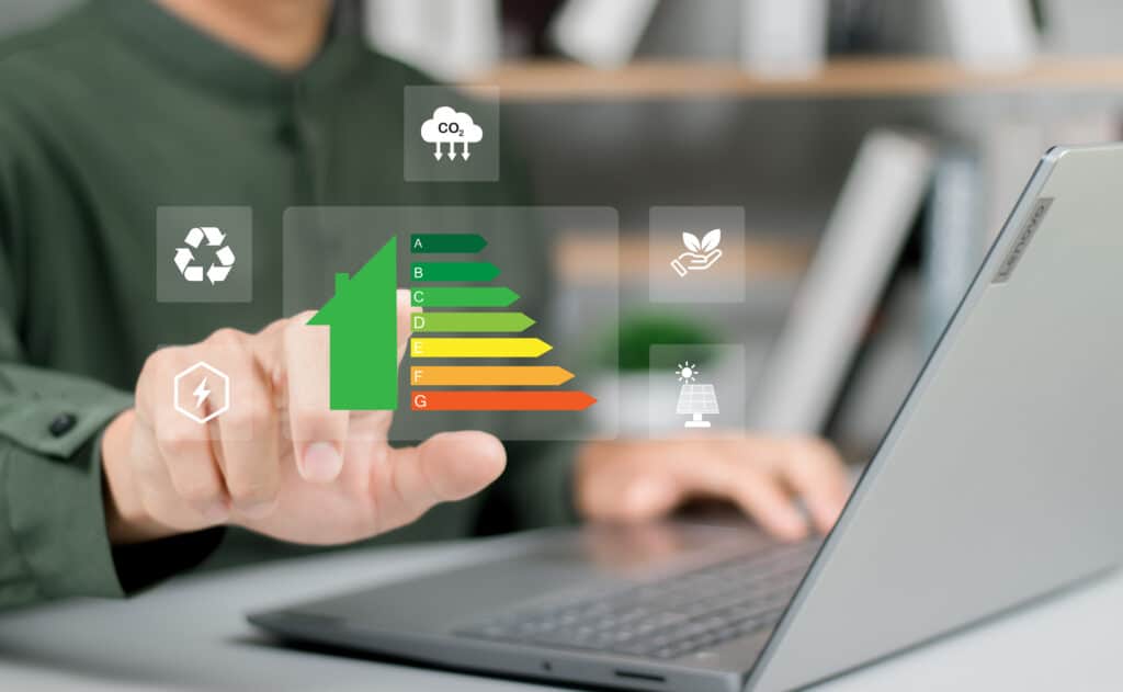 Main pointant une icône de maison avec étiquette de classe énergétique A-G, entourée d'icônes écologiques (CO2, recyclage, énergie, solaire).
